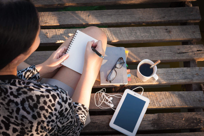 women takes notes with a pen and notepad