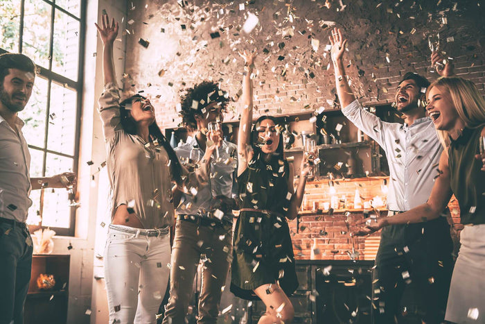 friends throw confetti to celebrate the new year